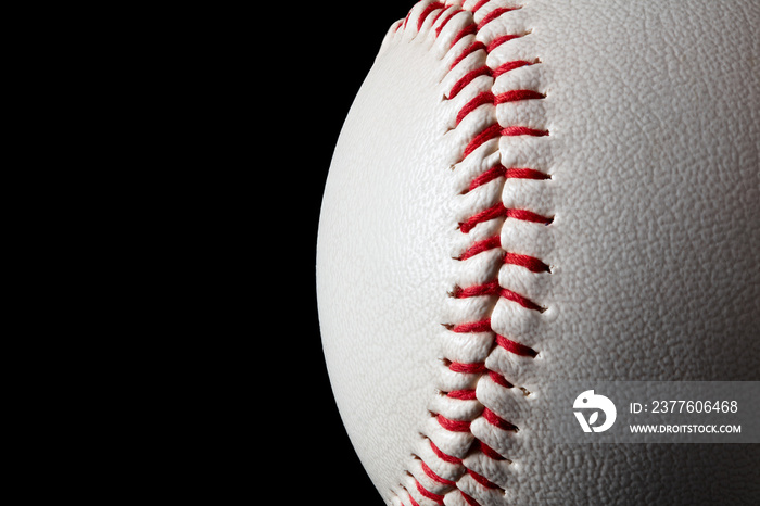 Macro close-up baseball ball with stiches and seam isolated on black background