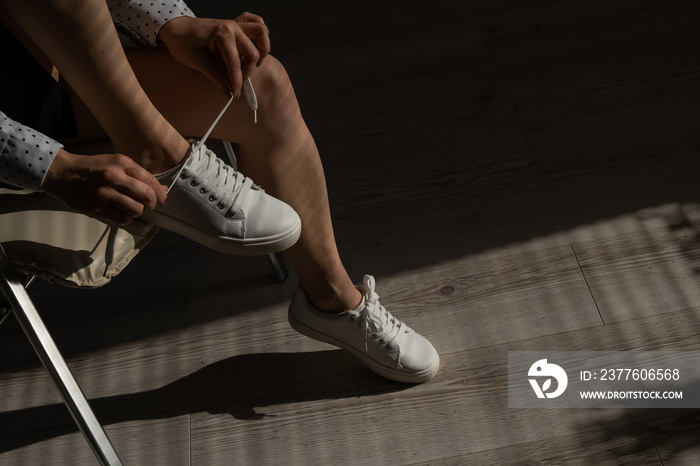 Woman put on new white leather sneakers