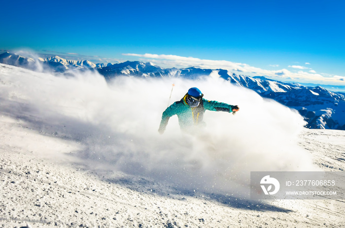 Professional skier at full speed ski downhill on fresh snow do carving in ski resort while training for competition in ski resort with mountains background