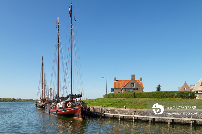 Old sailing ships along the quay in the picturesque village of Makkum, Netherlands.