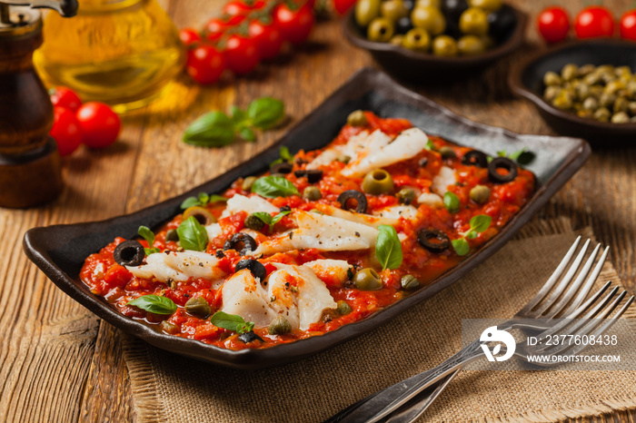 Cod in Italian in tomatoes with olives and capers.