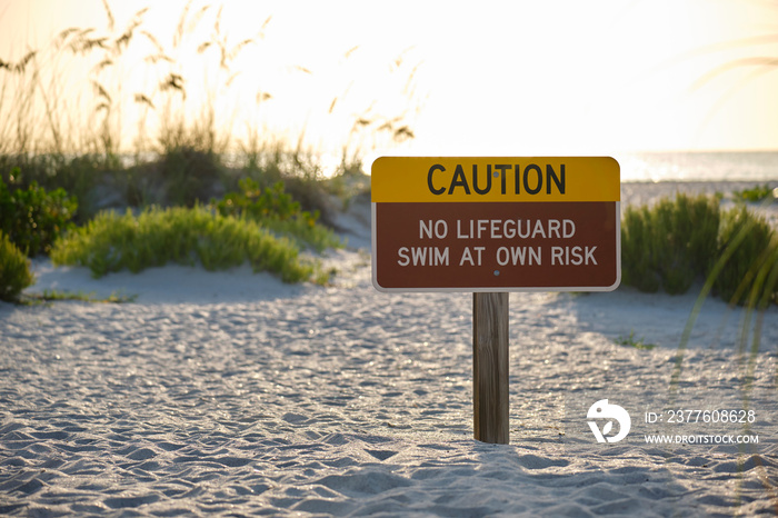 Warning sign poster on sea side beach saying that there is no lifeguard on duty