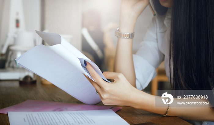 Young woman thinking and read information from paper in hand