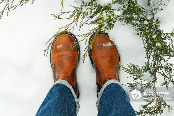 Woman in jeans and boots standing outdoor in winter