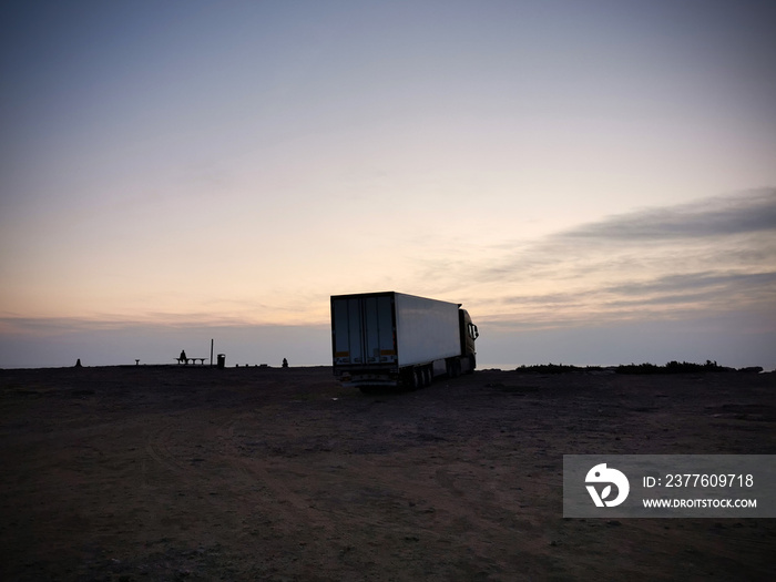 silhouette of a truck on a background of sea sunset