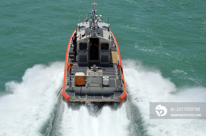 Angled overhead view of a speeding U.S. Coast Guard patrol boat.