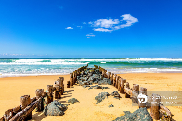 View of wooden pillars and stones on the beach of Seignosse, Landes, France