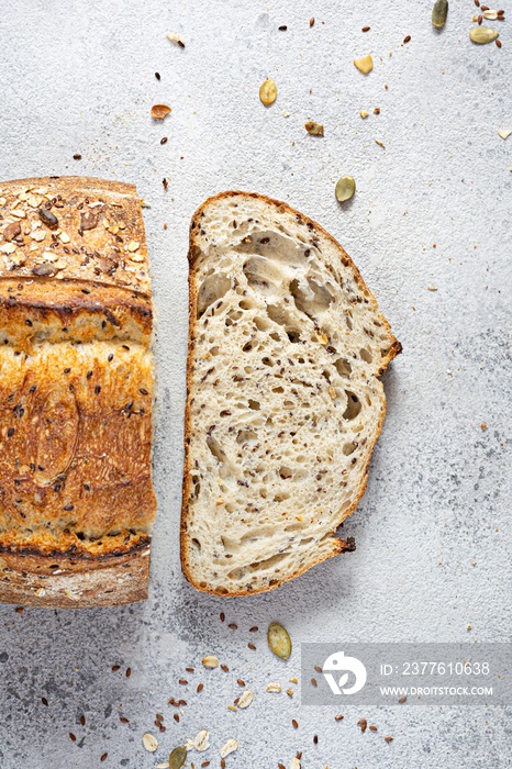 Fresh homemade bread (slice) from whole grain sourdough flour with the addition of bran, seeds (sunflower, pumpkin, flax, sesame) and oatmeal flakes. Healthy food. High quality photo.