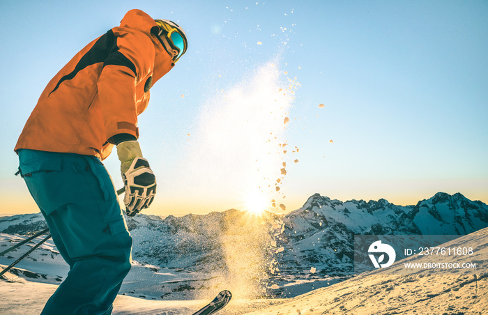 Expert professional skier at sunset on relax moment in french alps ski resort - Winter sport concept with adventure guy on mountain top ready to ride down - Side view point with teal and orange filter