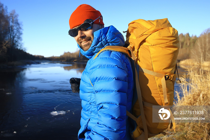 man in sports down jacket landscape winter trekking / down jacket on a tourist, outdoor activities in the north, seasonal landscape