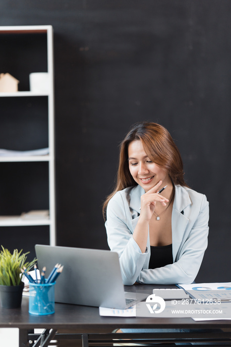 Asian woman working with laptop in her office. business financial concept.