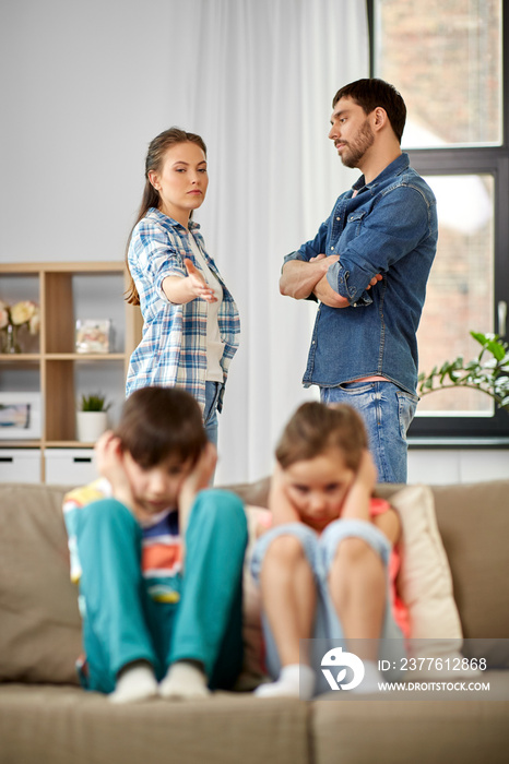 family problem, conflict and people concept - sad children closing ears while their parents quarreling at home