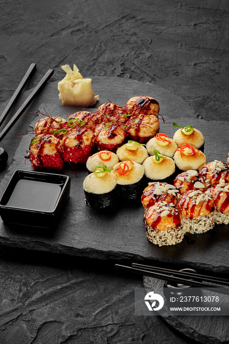 Baked rolls served for two with soy sauce and ginger on black board