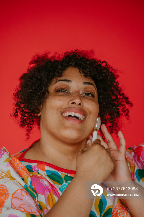 portrait of a plus size black person using a face roller