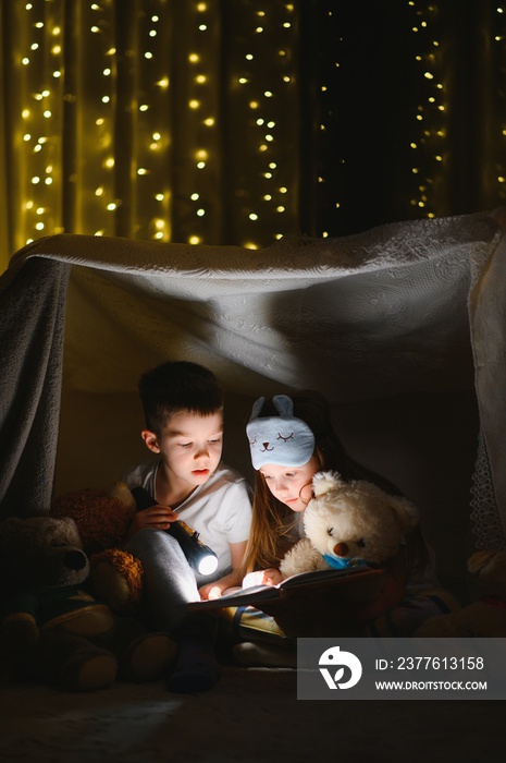 Little children reading bedtime story at home