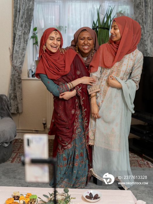 Smiling women posing for picture during Ramadan celebration at home