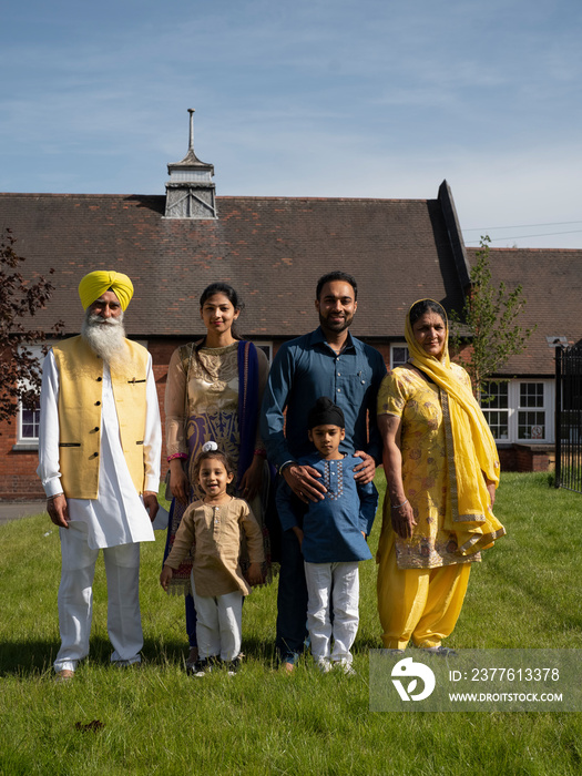 Portrait of three-generation family (2-3,6-7) in traditional clothing