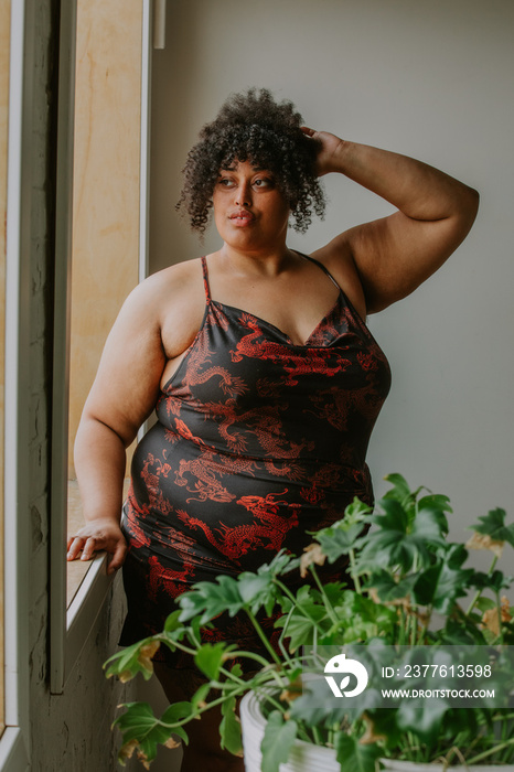 portrait of a plus size afro indigenous person looking out the window