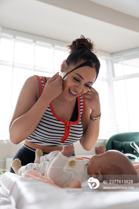 Mother smiling to newborn baby girl at home