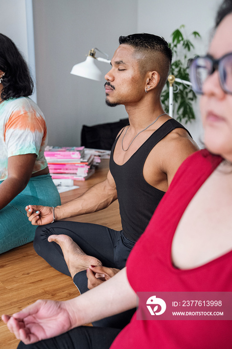 Group of friends meditating and doing yoga at home