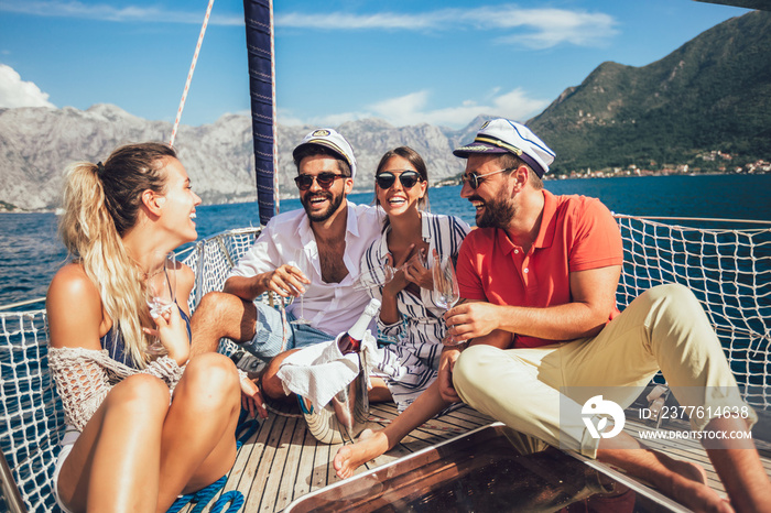 Smiling friends with glasses of champagne on yacht. Vacation, travel, sea, friendship and people concept