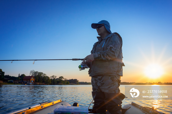 A fisherman fishing in a lake at sunset