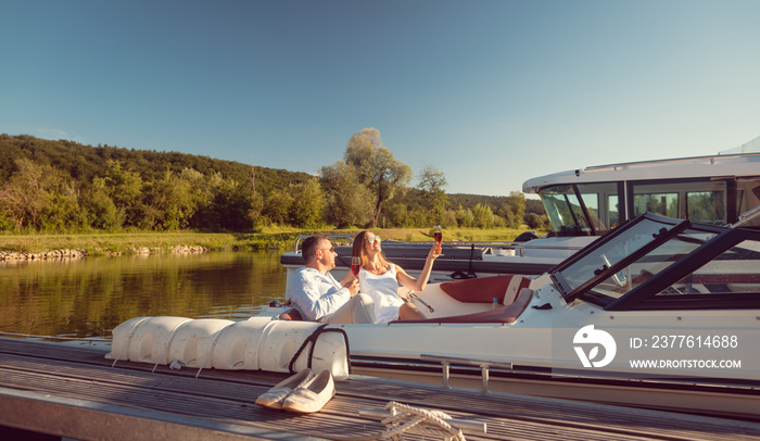 Woman and man relaxing on their river yacht