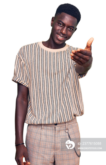 Young african american man wearing casual clothes smiling friendly offering handshake as greeting and welcoming. successful business.