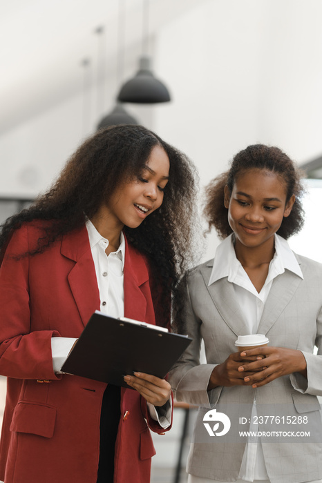 Young diverse african american female coworkers working together on start up project. Business people meeting around a boardroom table discussing creative concept