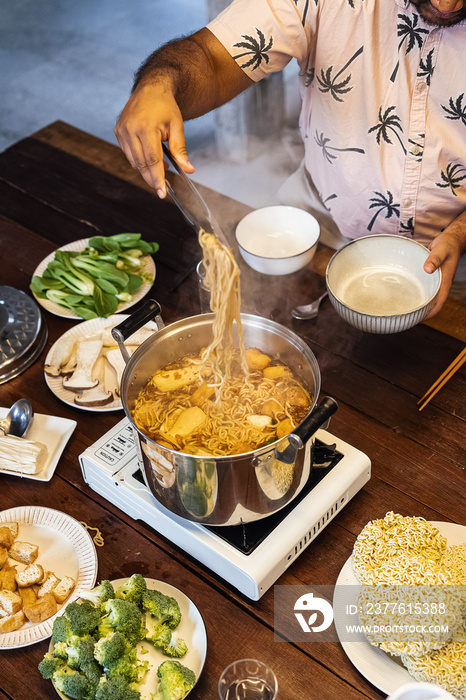 Family dinner eating hotpot together with the parents and kids in the evening