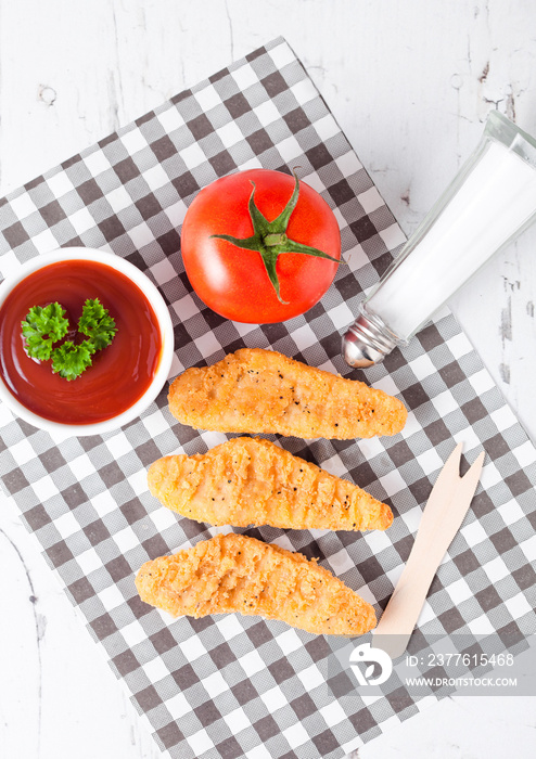 Fried chicken dippers on chopping board with sauce