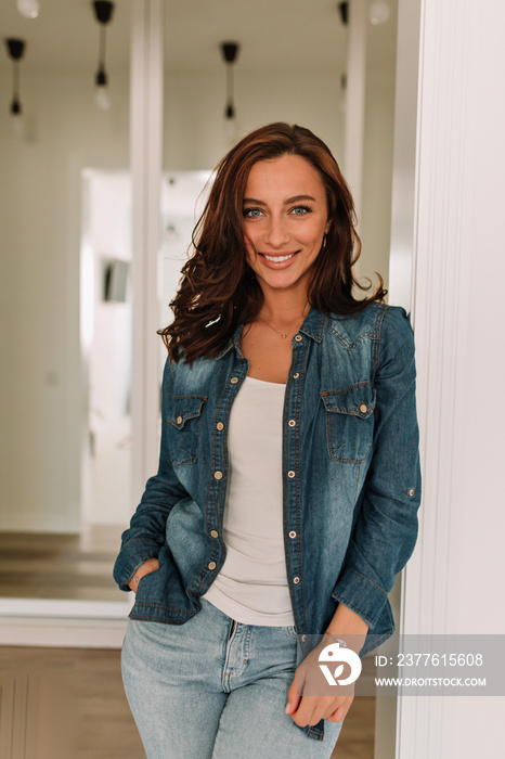 Vertical photo of europen woman with dark hair and tanned skin looking at camera