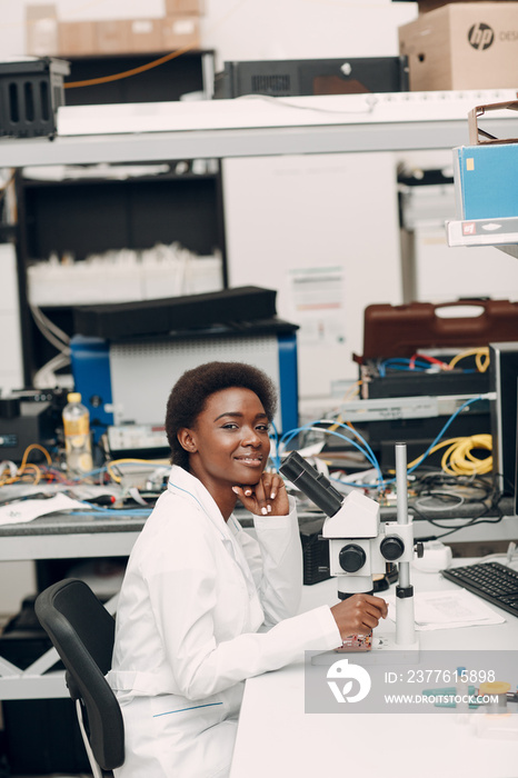 Scientist african american woman working in laboratory with electronic tech instruments and microscope. Research and development of electronic devices by color black woman.