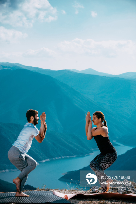 Smiling couple making yoga exercises outdoors