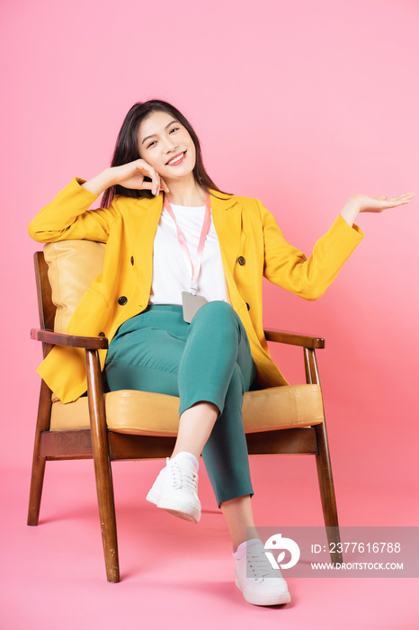 Image of young Asian businesswoman sitting on chair