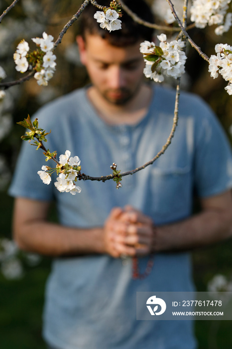 Young man praying outside in Eure, France.