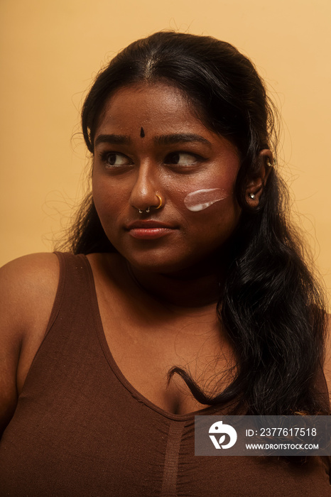 South Asian female solo lifestyle studio portrait skin care shot