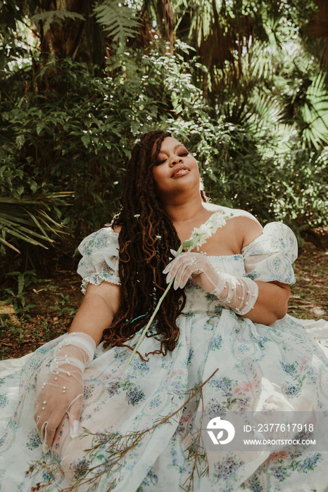 plus size African American woman sitting on the ground in a big dress eyes closed