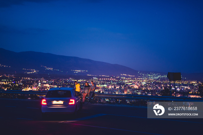 Three friends at night enjoying the view