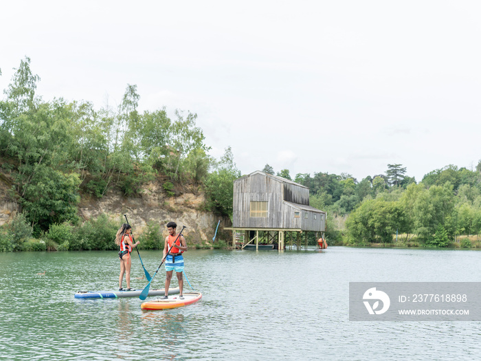 Friends paddleboarding on lake