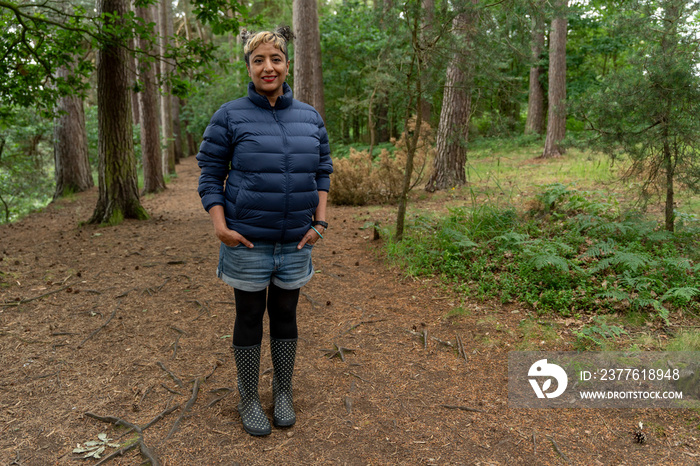 Portrait of smiling woman hiking in forest