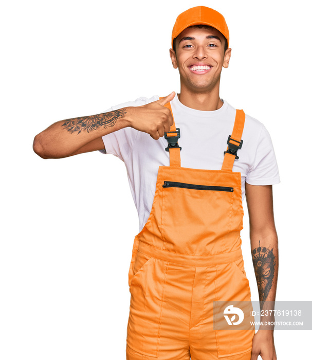 Young handsome african american man wearing handyman uniform doing happy thumbs up gesture with hand. approving expression looking at the camera showing success.