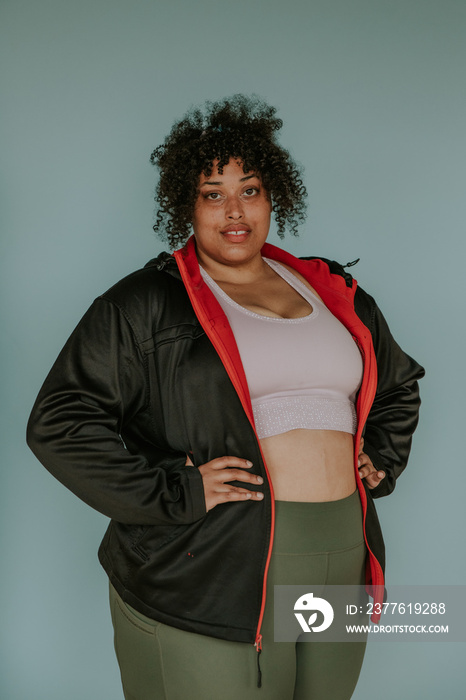 portrait of a plus size afro indigenous person looking at camera wearing athletic gear