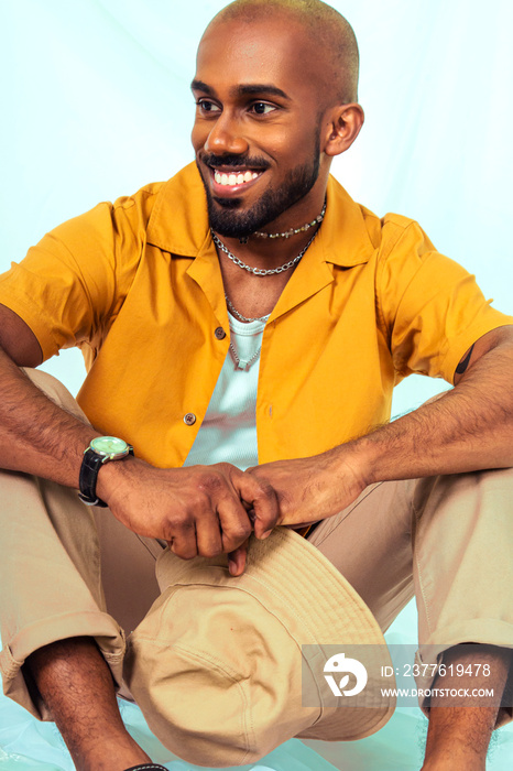 Malaysian Indian men laughing and posing together against a cloth backdrop in a studio setting, wearing fashionable clothing