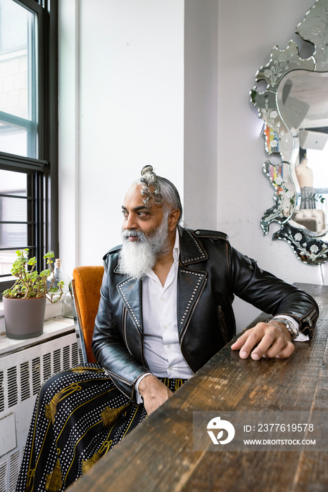 portrait of man with gray beard wearing leather and skirt