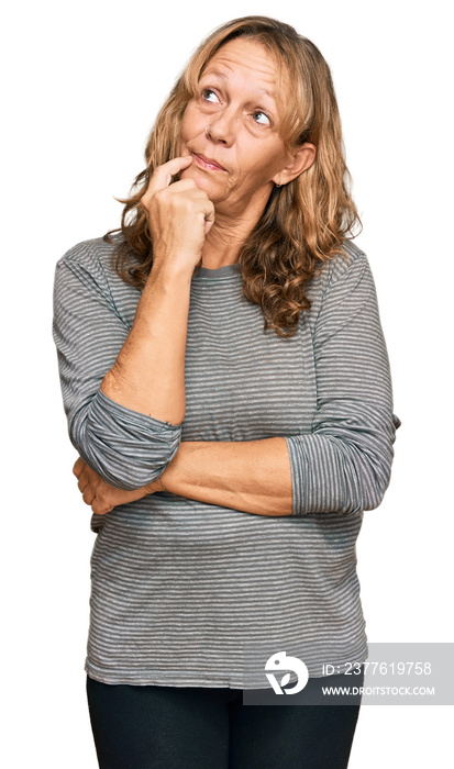 Middle age blonde woman wearing casual clothes serious face thinking about question with hand on chin, thoughtful about confusing idea