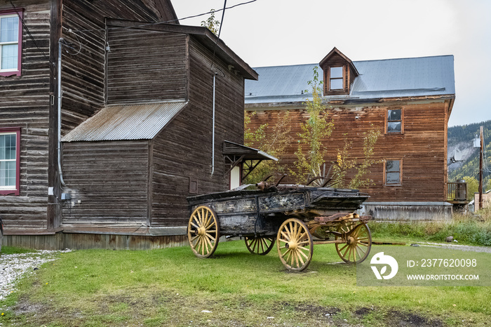 Dawson city in Yukon, Canada, colorful houses in the ancient village of the gold rush, with an ancient wagon