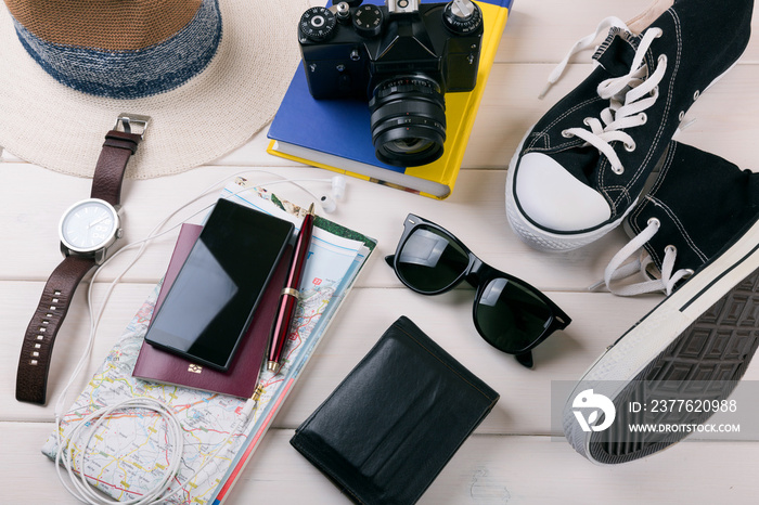 travelers vacation items on white wooden table