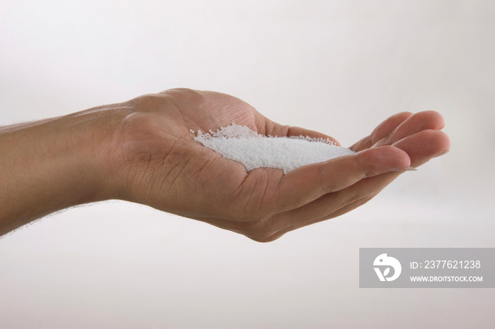 Hand holding white polystyrene foam beads ball drop