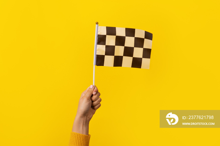 checkered flag in hand over yellow background